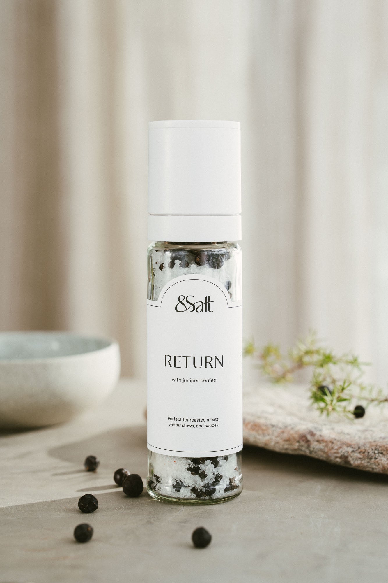 RETURN premium sea salt and juniper  blend in a tall glass grinder.