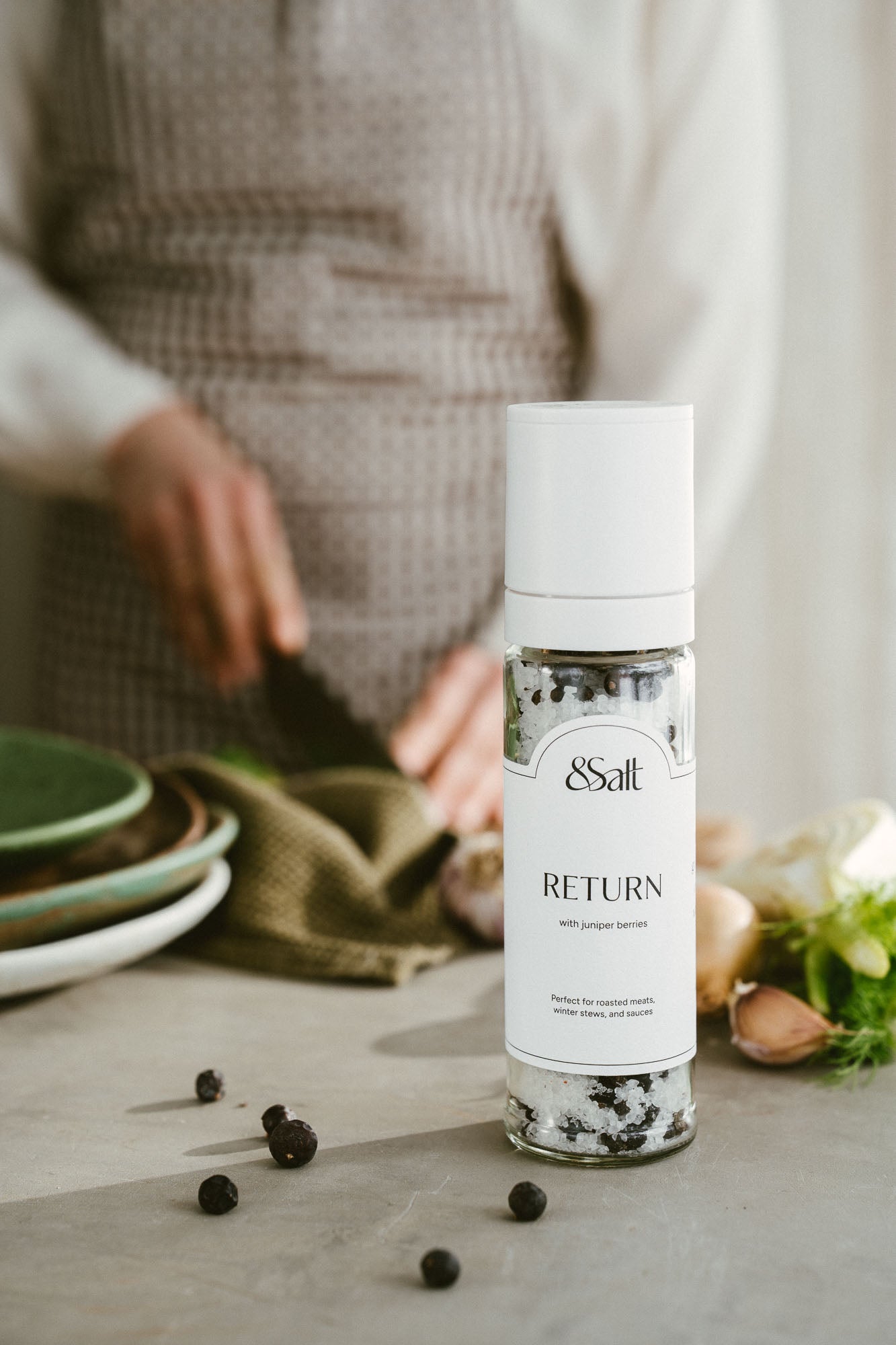 Bottle of &Salt with 'RETURN' text on a table with ingredients