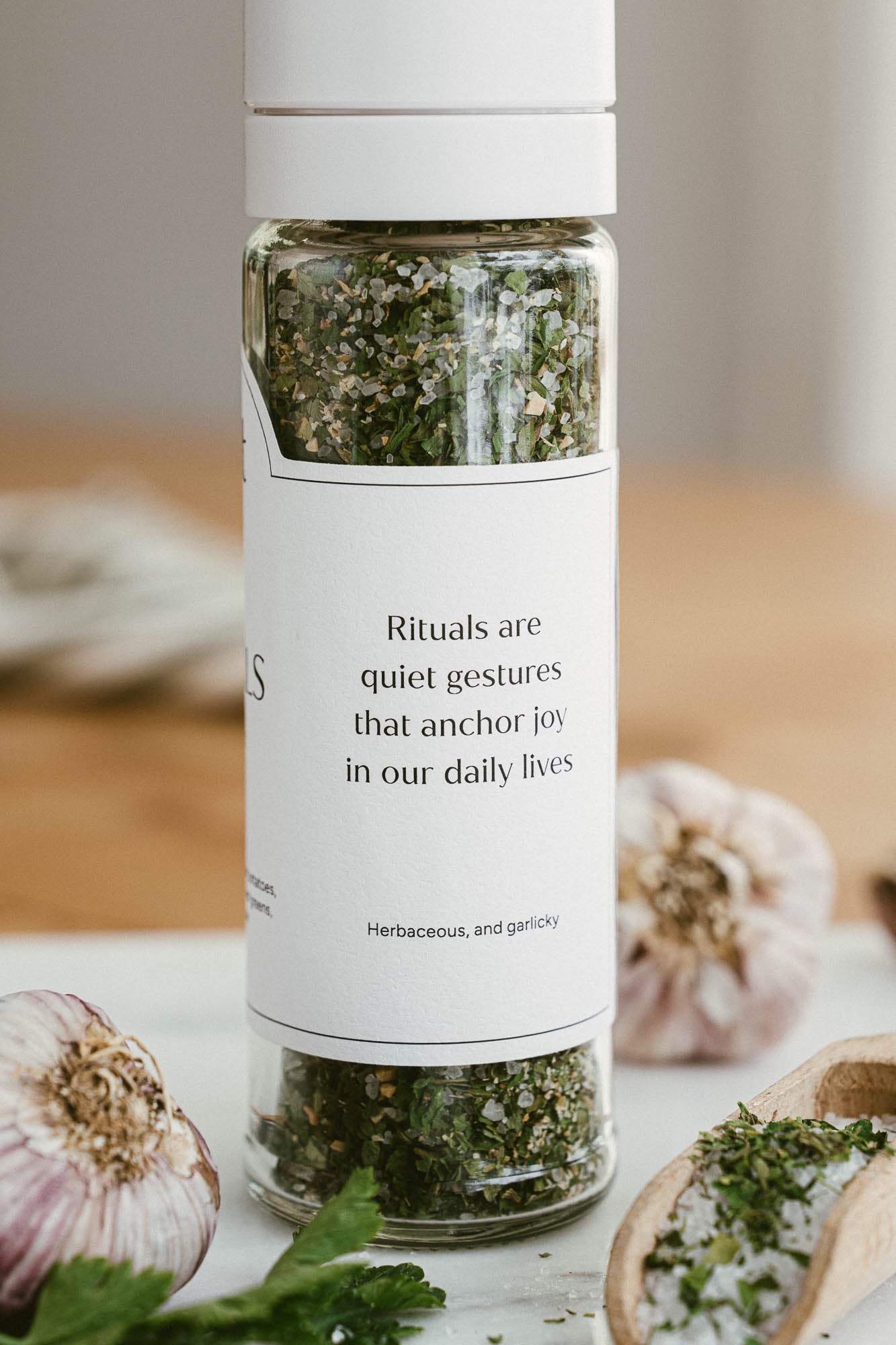 Bottle of salt with herbs with a label on a wooden surface